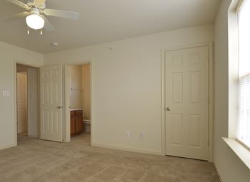 Bedroom with two doors and a ceiling fan at The Pointe at Manorgreen Townhomes, Maryland